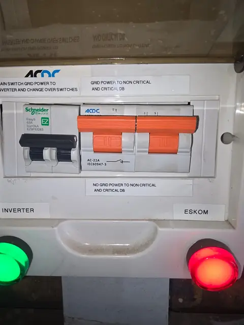 Manual changeover panel separating grid power from a backup supply, with Eskom and inverter indicator lamps
