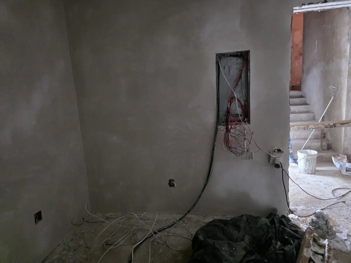 Room in a new-build home with the distribution board wiring roughed in before plastering